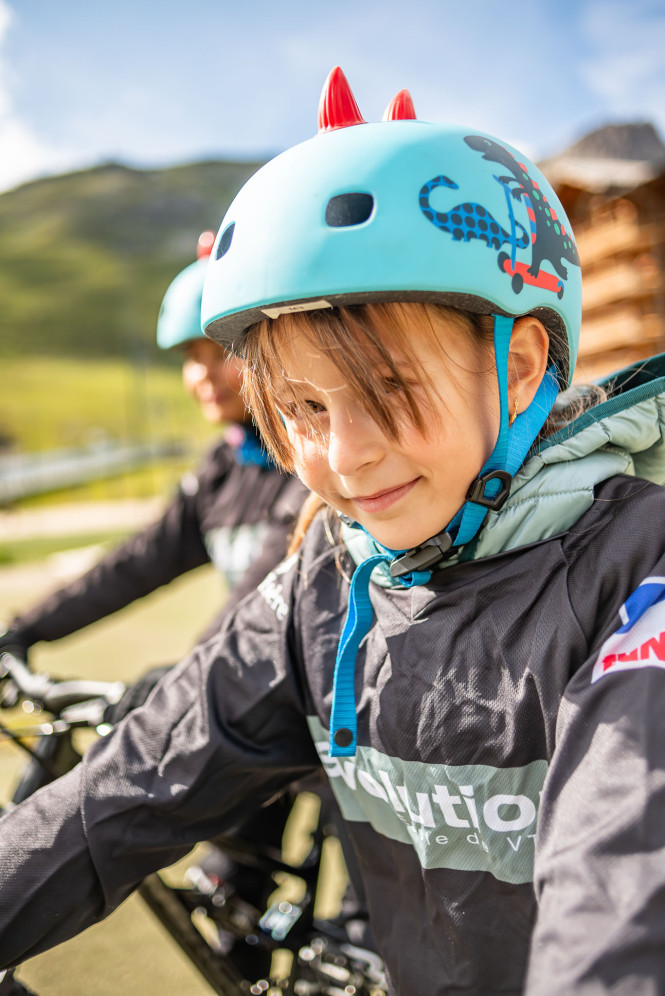 Child wearing a helmet during a mountain bike lesson with Evolution 2