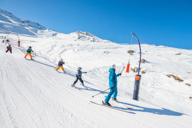 Enfants suivant un moniteur de ski lors d'un cours collectif à Val Thorens avec Evolution 2