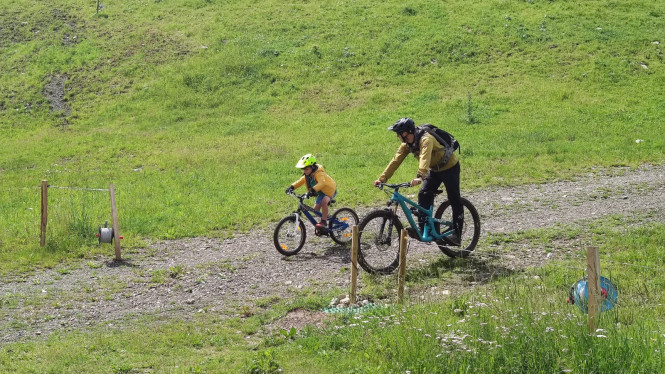 un enfant qui prend un cours de VTT avec un moniteur Evolution 2 à La Clusaz