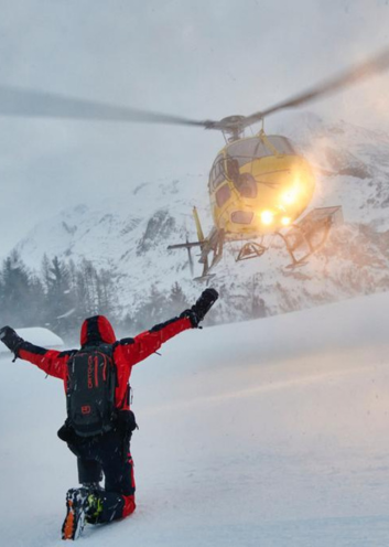 Mountain guide supervising a group of skiers on a heliskiing trip in La Rosière