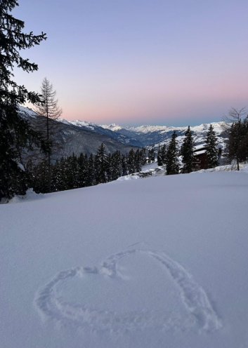Soleil levant et cœur dessiné dans la neige