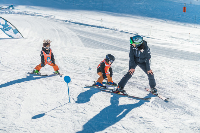 Two children following their ski instructor during a beginner lesson in Tignes