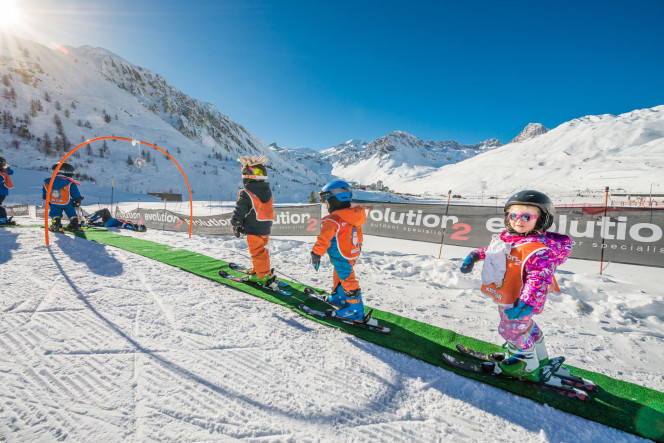 Children at the Tignes kids club learning to ski on the magic carpet