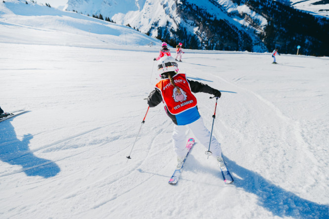 Enfant qui suit un cours de ski collectif Evolution 2 à La Clusaz