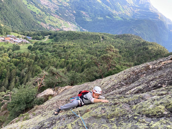 Evolution 2 client climbing on a rock face during an outdoor rock climbing activity.