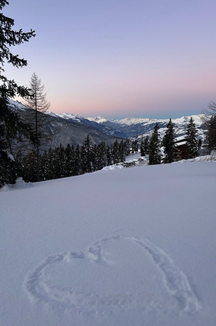 Soleil levant et cœur dessiné dans la neige