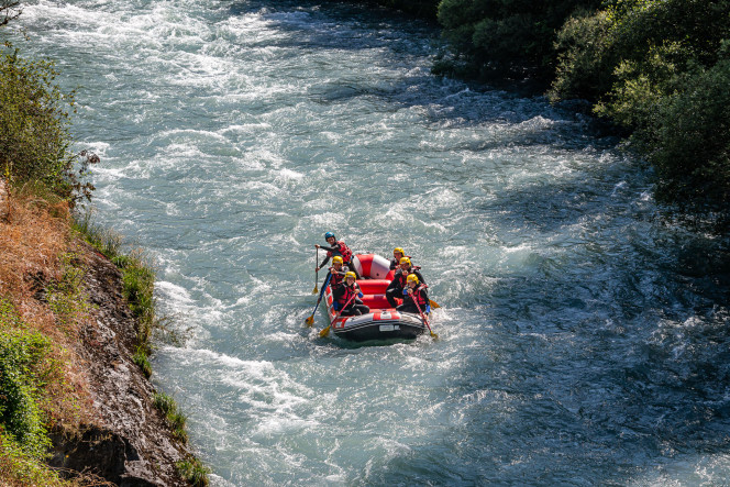 Group of friends rafting down the rapids on the Isère River