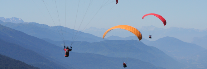 3 parapentes dans les airs au dessus des montagnes