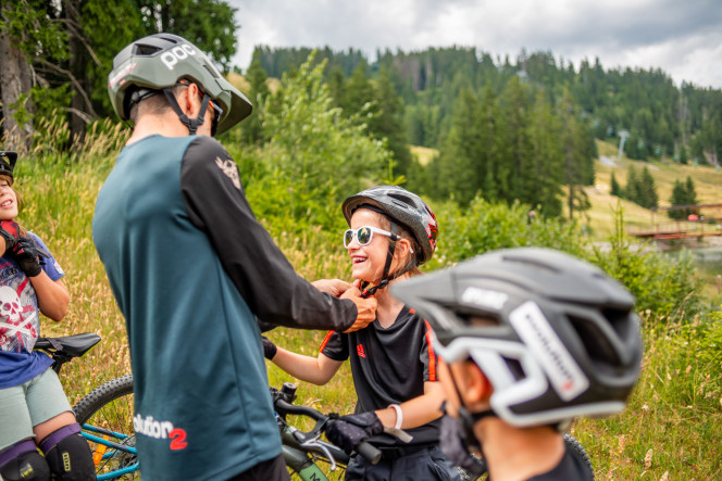 Evolution 2 instructor putting a mountain bike helmet on a child