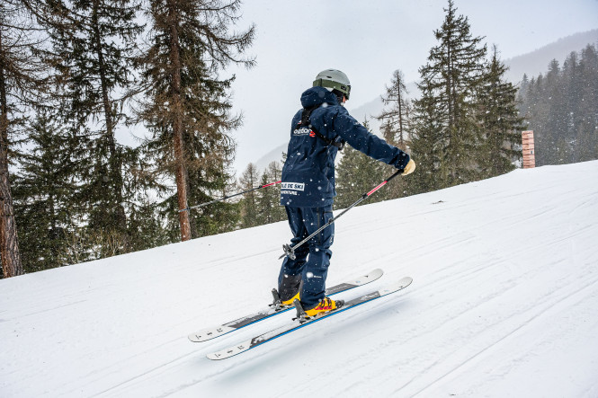 Evolution 2 ski instructor skiing in Sainte Foy Tarentaise in snowfall, seen from behind