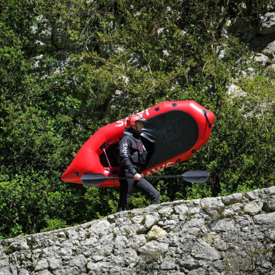 Homme portant son packraft avant l'activité