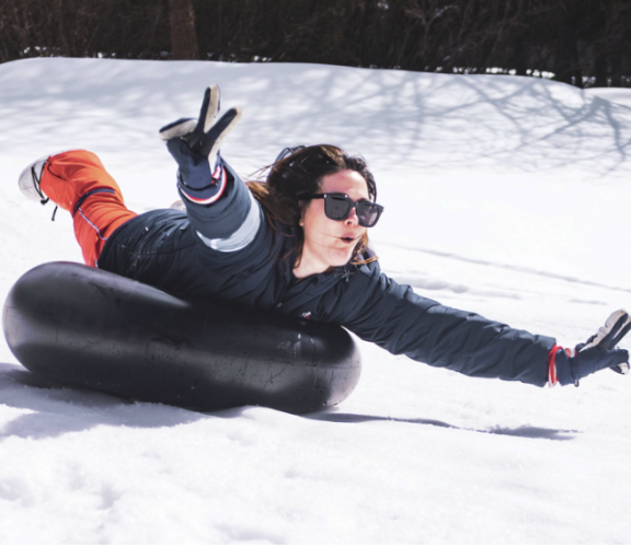 Femme glissant sur une bouée dans la neige