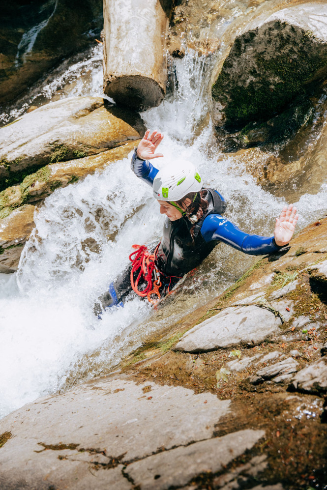 Femme en train de faire du toboggan naturel en canyoning