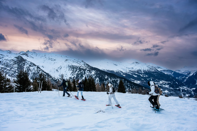 Winter landscape at dusk, with snowshoe hikers