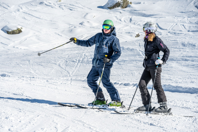 Moniteur de ski expliquant à son élève adulte