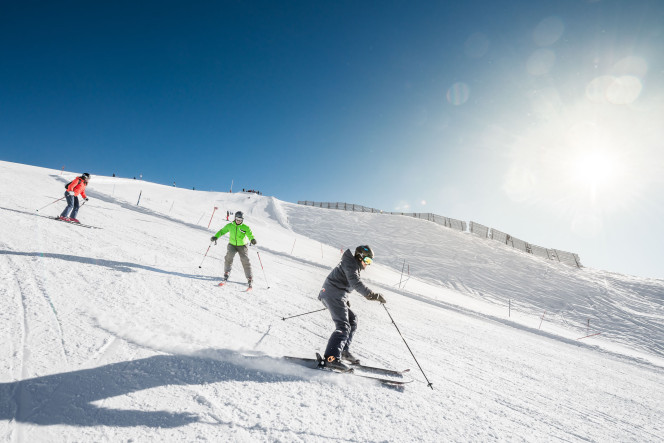 Adultes en cours de ski derrière un moniteur Evolution 2 à Tignes