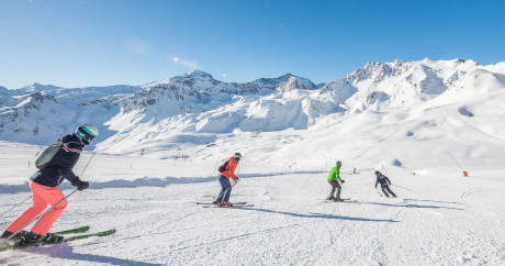 alt="Cours collectifs de ski adultes Evolution 2 Tignes, groupe de 8 personnes maximum en pleine progression sur les pistes"