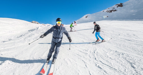 alt="Cours collectifs de ski adultes Evolution 2 Tignes, groupe de 8 personnes maximum en pleine progression sur les pistes"